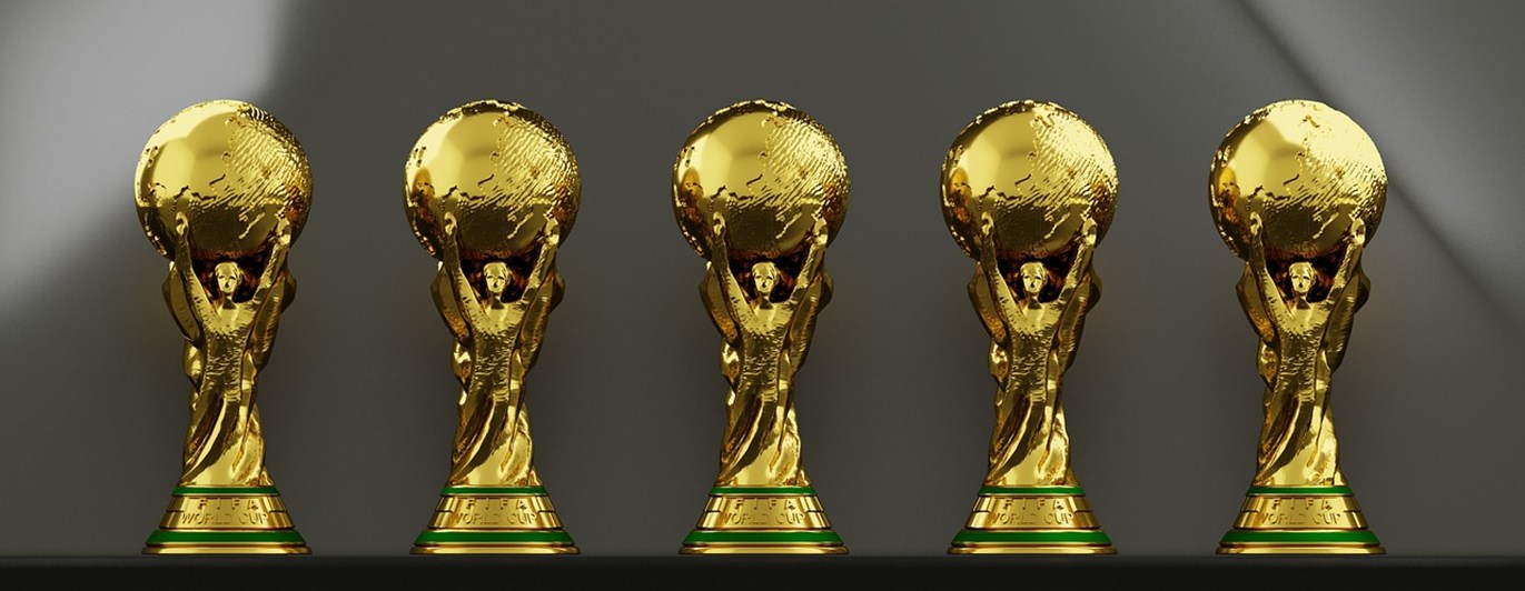 Fem guldiga troféer i rad.