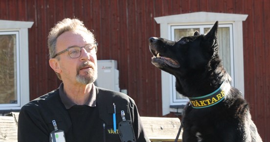 Bild på en schäfer tillsammans med sin husse. Hunden är väktarhund.