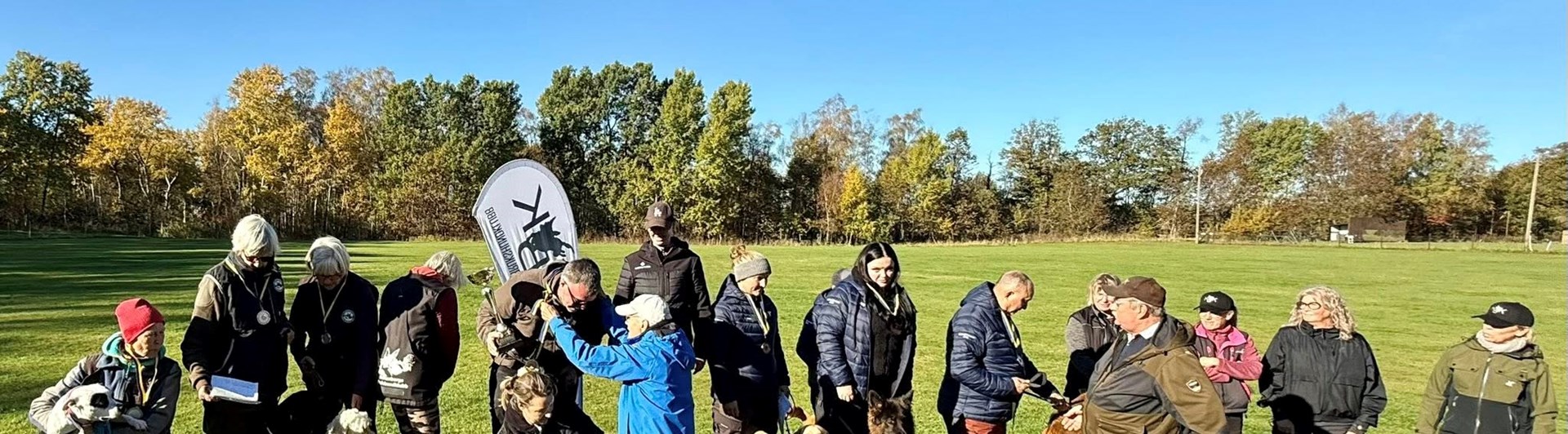 Prispall med lyckliga vinnare med sina hundar