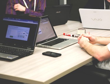 Människor vid sina datorer runt ett bord