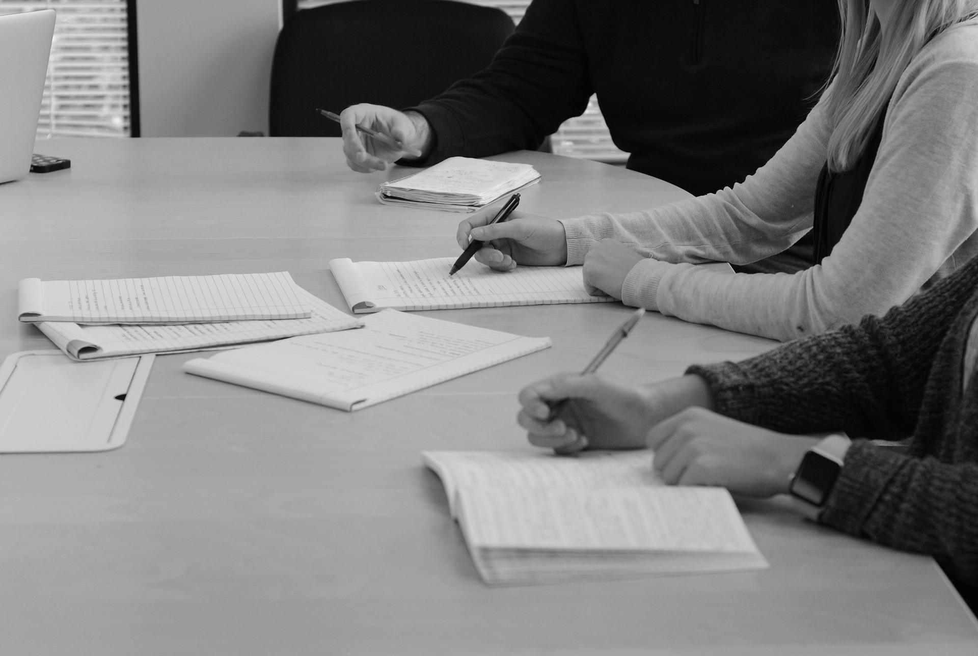 Bild på mötesdeltagare som skriver.