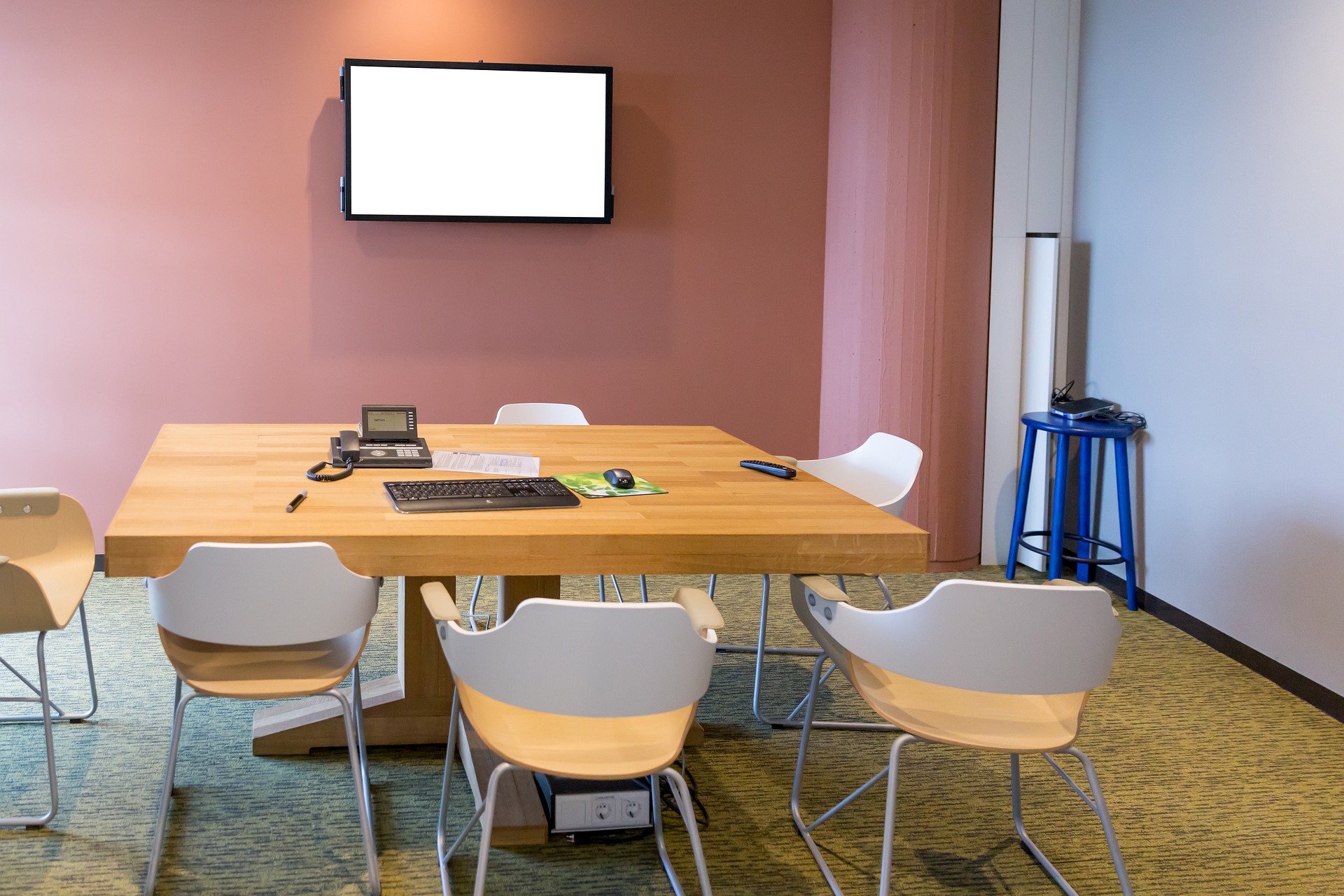 Bild på mindre konferensrum med bord och stolar.